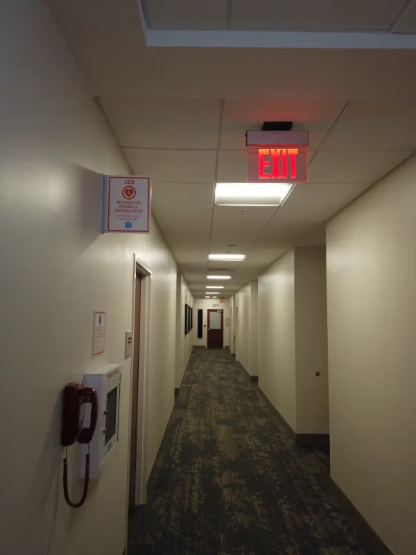a hallway stretches out of view, various signage and implements adorn the walls