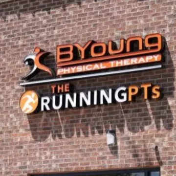 Sign on a brick wall reading BYoung Physical Therapy and The Running PTs