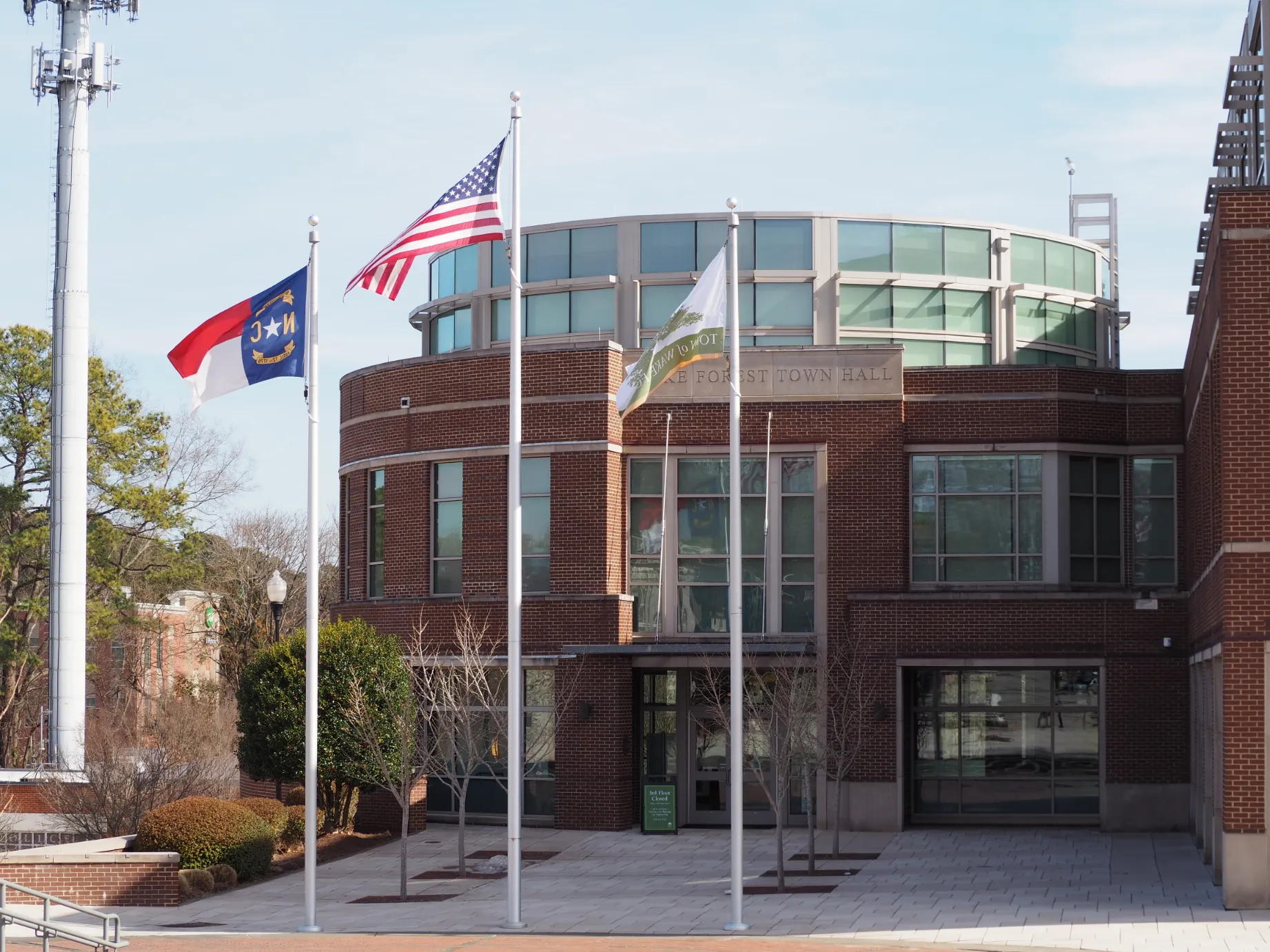 Wake Forest Town Hall building with US, North Carolina, and town flags flying in front